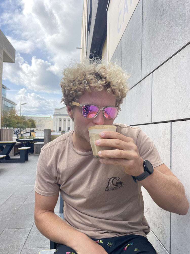 Pink mirrored polarised sunglasses on person, with clear frame and wood temples.