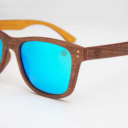 Wood-look sunglasses close-up with sky-blue mirrored lens and brown frame