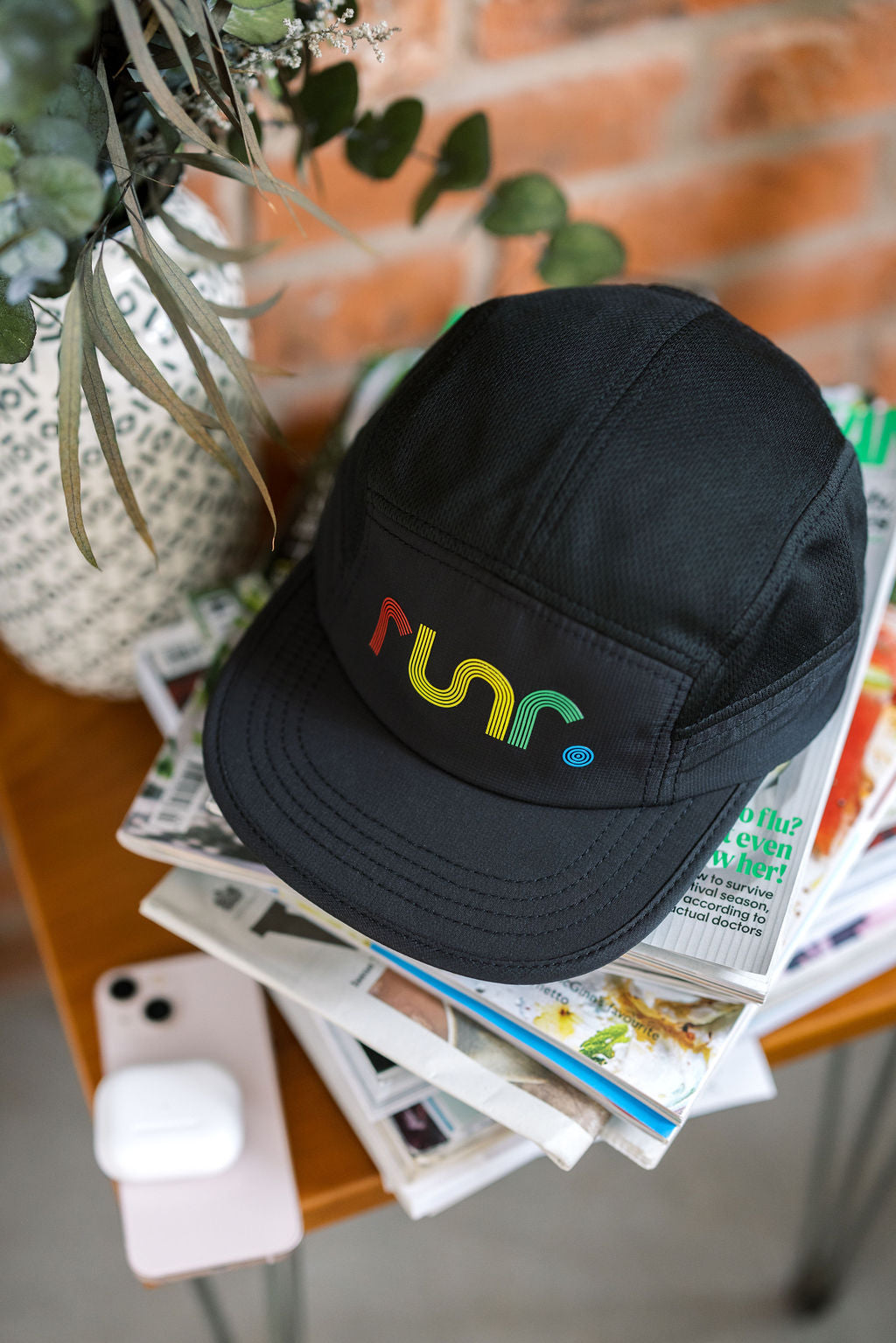 Black running cap with multicolor "run" logo on front panel