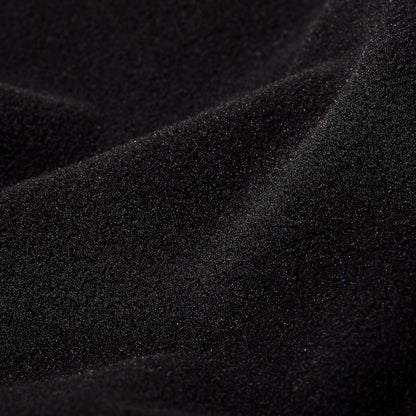 Black fleece jacket fabric close-up, textured surface.