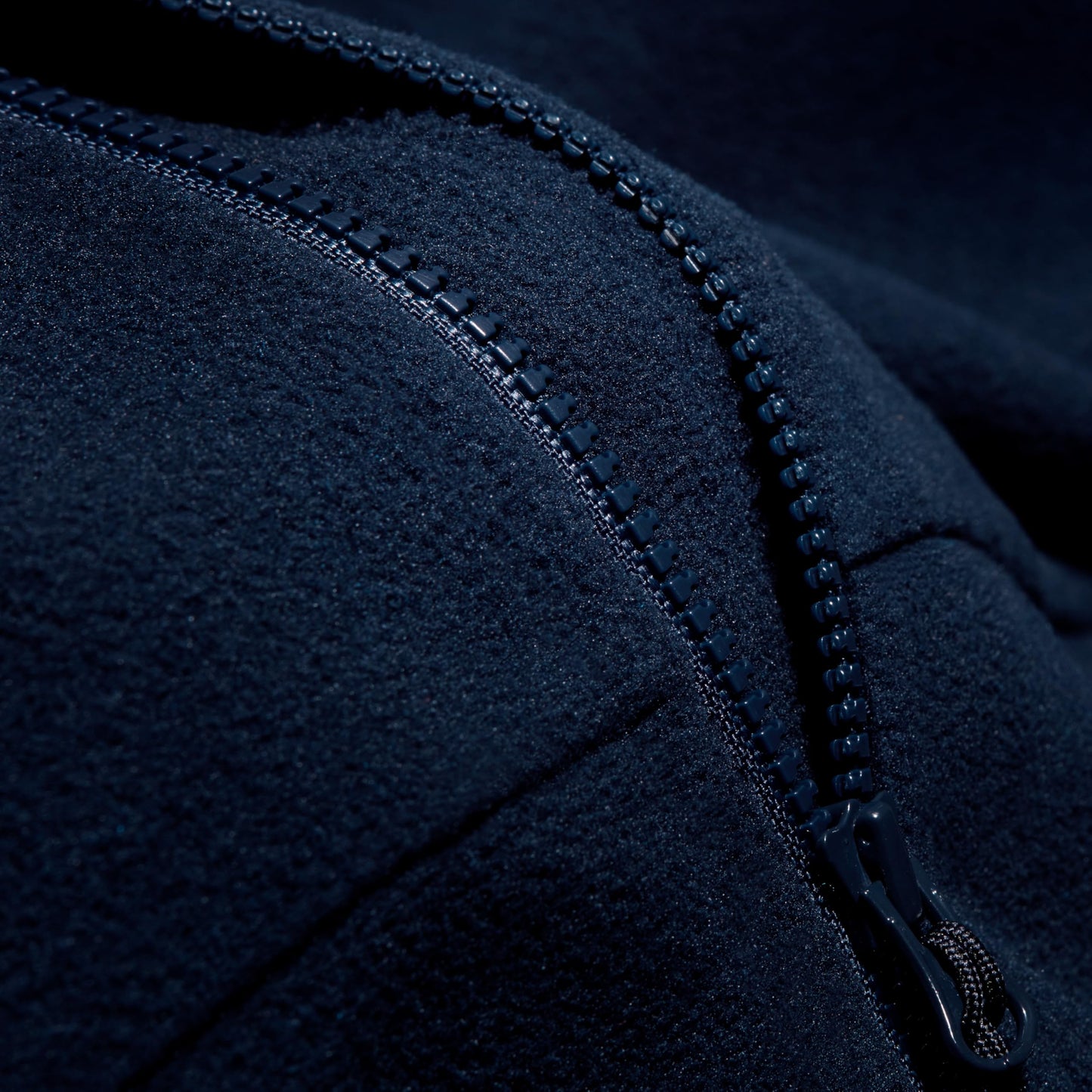 Navy fleece jacket zipper track and stitched seam detail