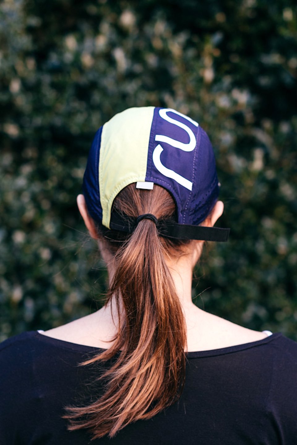 Technical running hat from behind, navy and lime panels with logo emblem