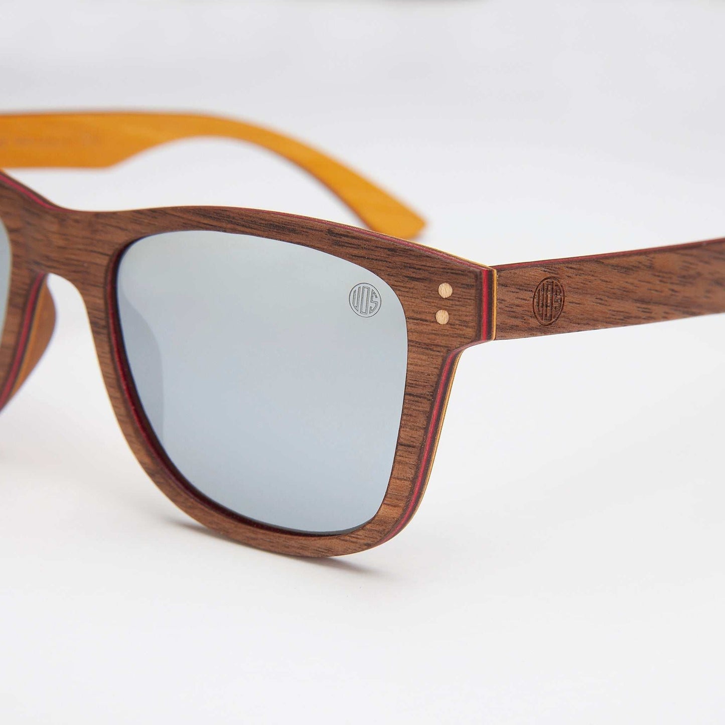Wood-grain sunglasses close-up: dark brown frame with gray lenses and logo detail