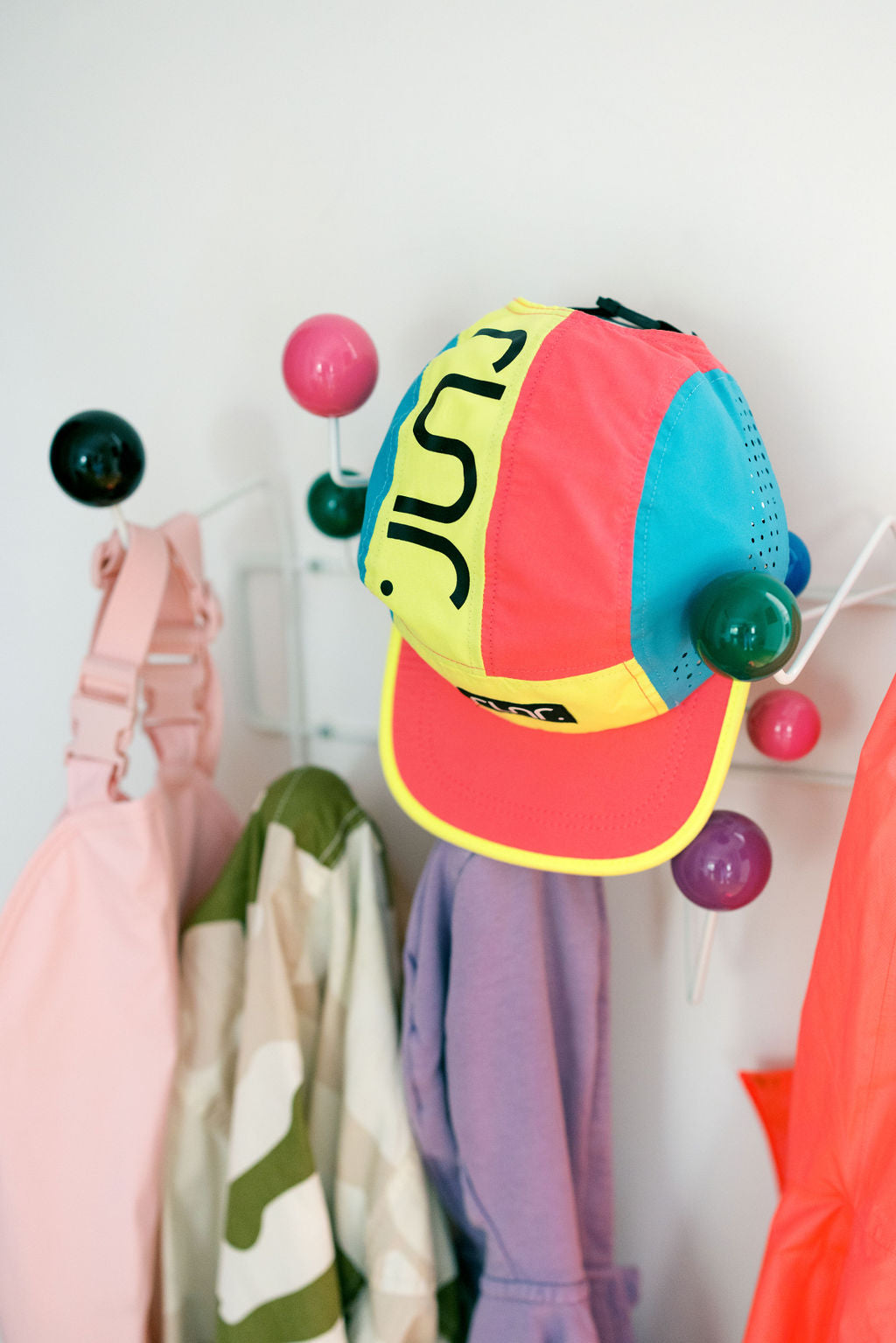 Technical running hat front panel with neon yellow U-shaped graphic and pink brim