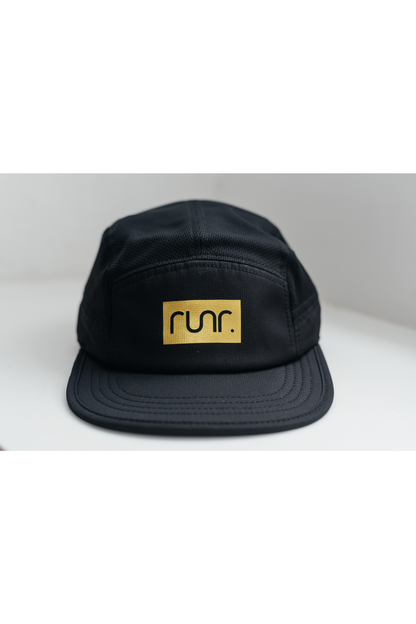 Black technical running hat with gold "run." logo patch