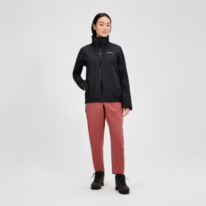 Person wearing a black jacket and red pants on a white background
