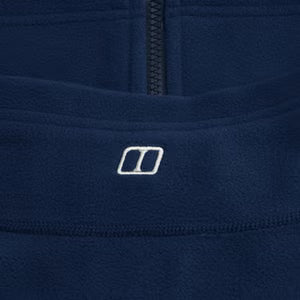 Close-up of a navy blue garment with a brand logo on a dark background