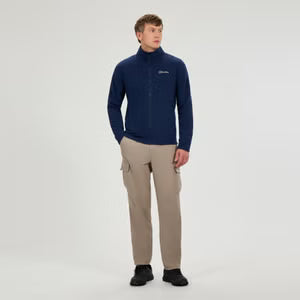 Man wearing a navy fleece pullover and beige pants on a white background