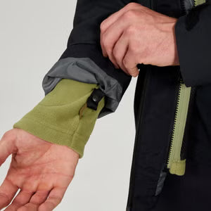 Close-up of a person adjusting the sleeve of a black jacket with green lining.