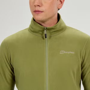 Person wearing a green fleece jacket with a brand logo on a light gray background