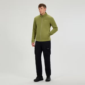 Man wearing a green fleece jacket and black pants on a white background
