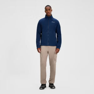 Man wearing a blue jacket and beige pants on a white background