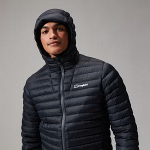 Person wearing a black puffer jacket with a brand logo on a gray background