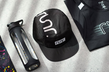Black RUNR running cap with white RUNR logo and front ventilation holes.