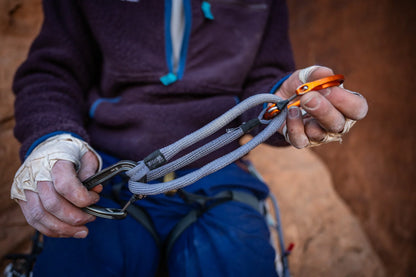 Grey climbing sling runner held with metal locking carabiners