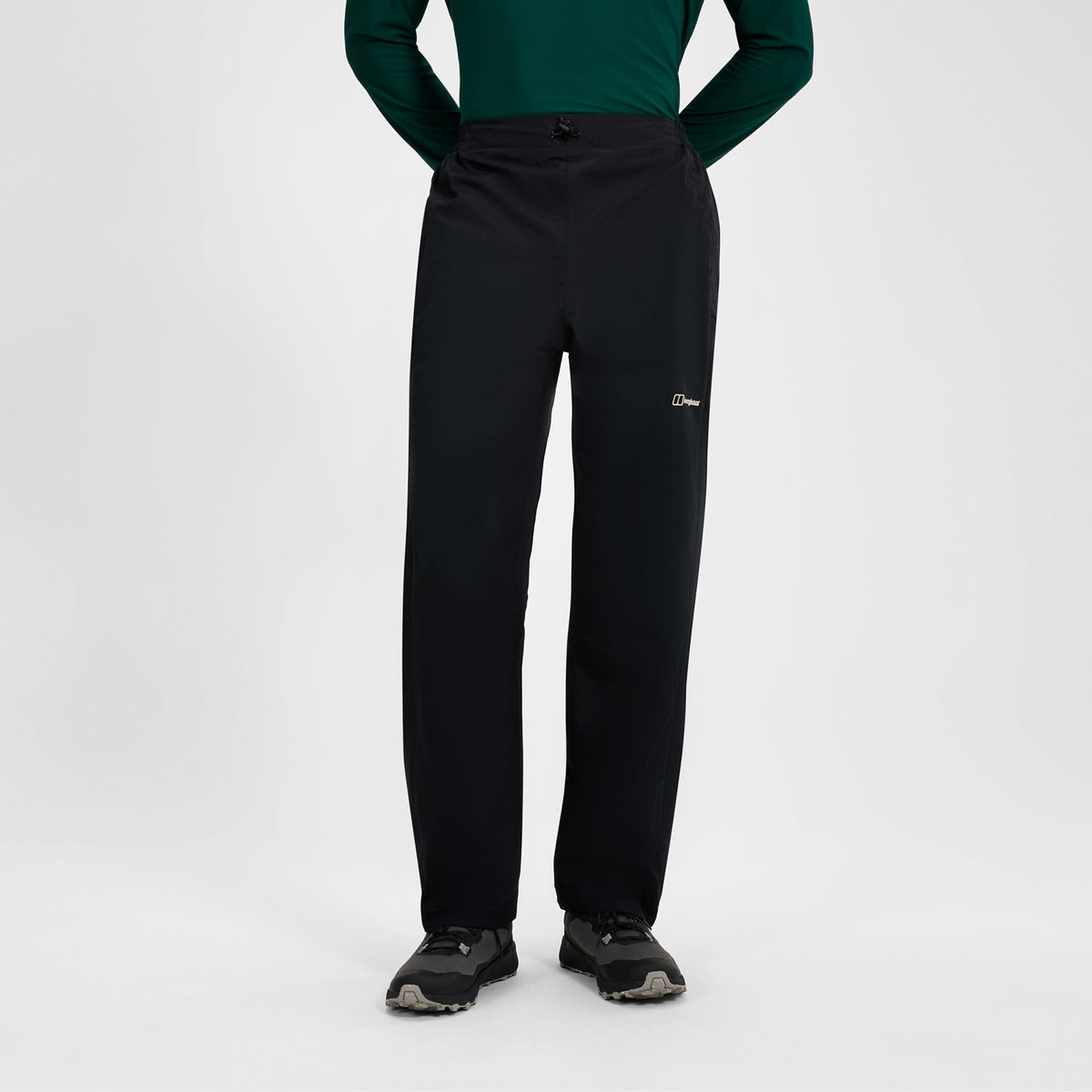 Black waterproof overtrousers with front fastening and logo on right thigh