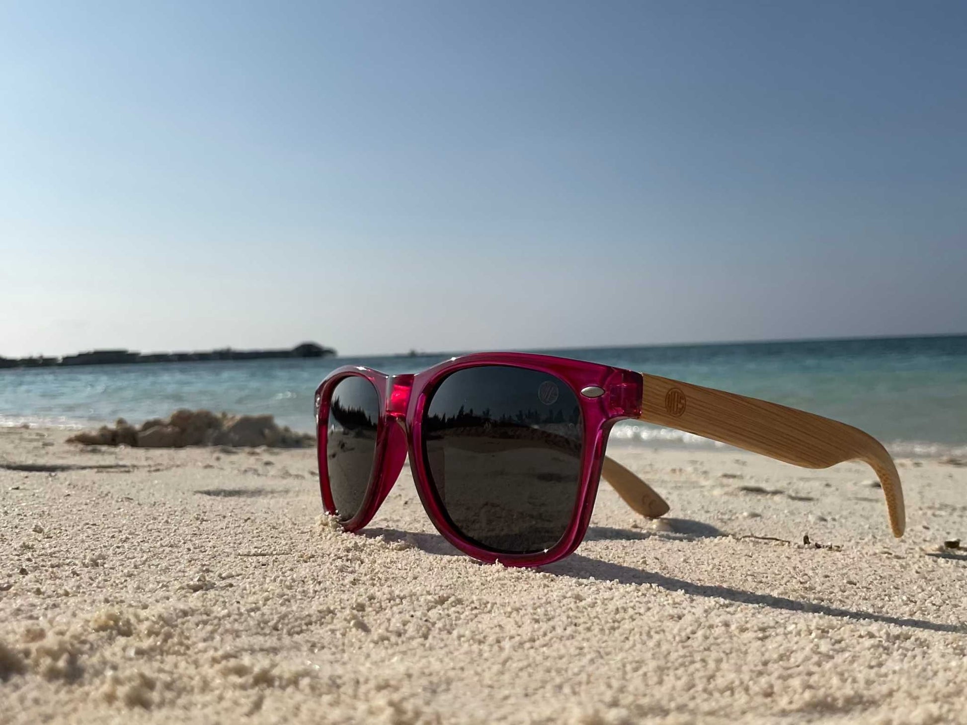 Red square sunglasses with dark lenses and bamboo-look arms