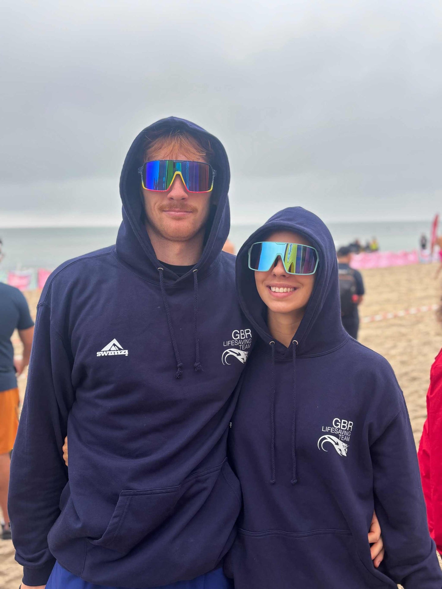 Wrap-around sports sunglasses on two people wearing navy hoodies