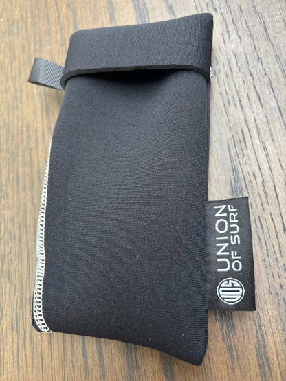 Dark gray sunglasses case with black strap and small black side label