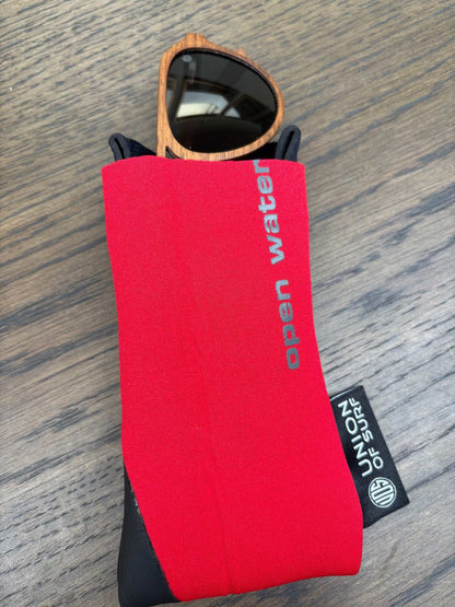 Two-tone red and black sunglasses case with strap, sunglasses tucked inside