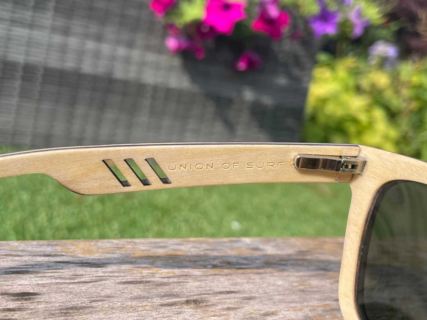 Sunglasses temple close-up with UNION OF SURF engraving and metal slider