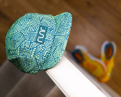 Green-and-teal geometric running hat with runr logo panel, side view