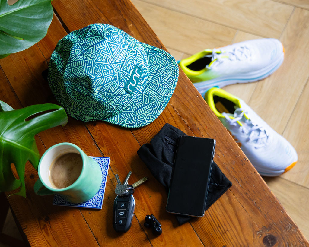 Geometric teal running hat lying on wood with brim facing up