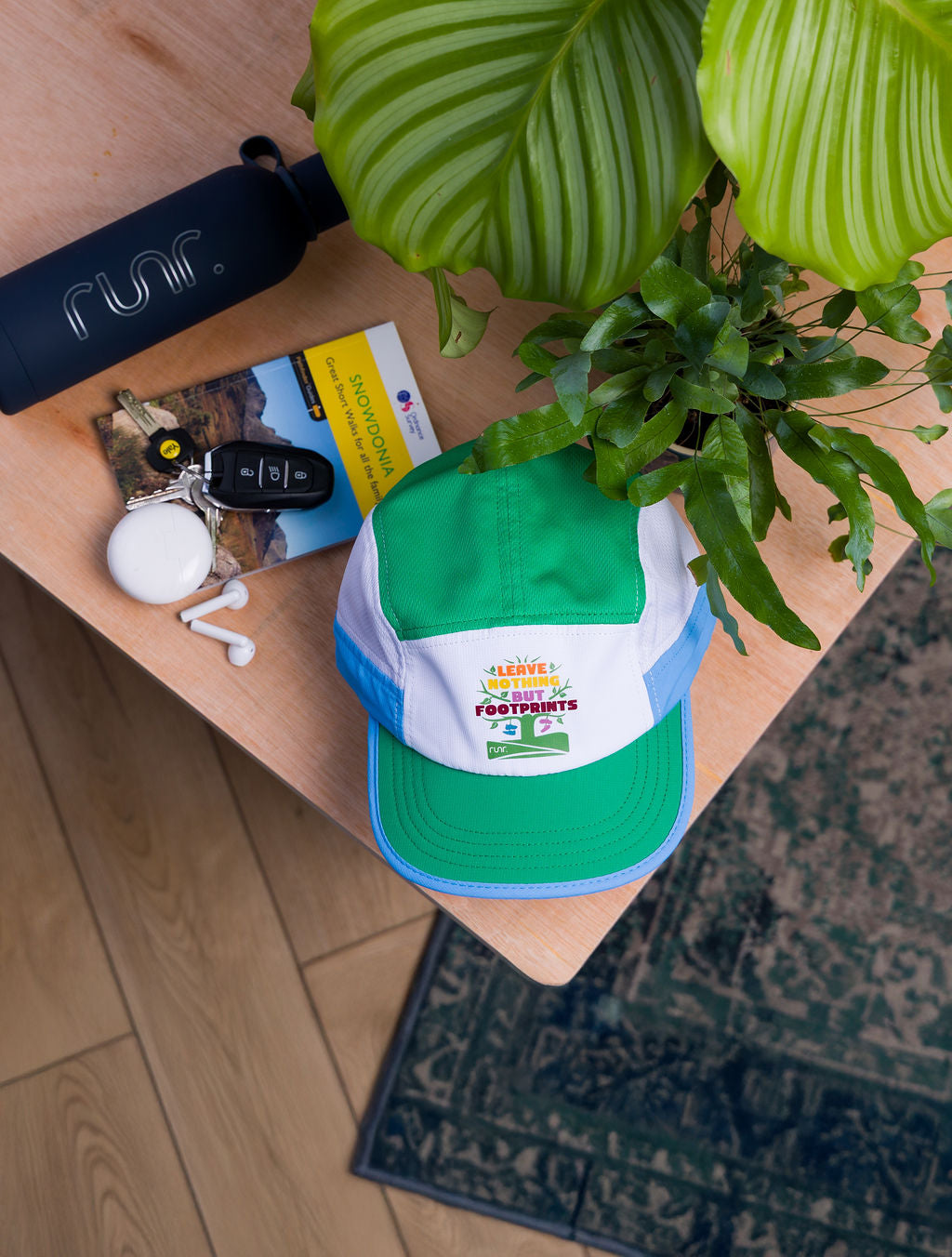 Technical running hat in green, white, and blue with front logo patch