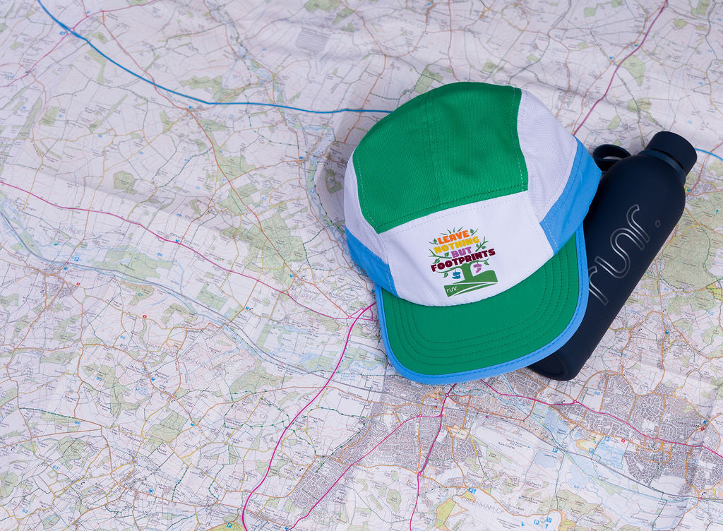 Technical running hat with green top, white front panel, and blue brim edge