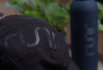 Black technical running hat with large rear graphic and stitched seams.