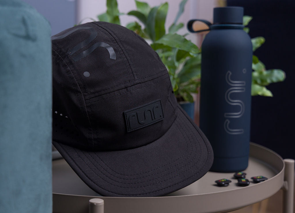 Black technical running hat with curved brim and rectangular Runr logo patch.