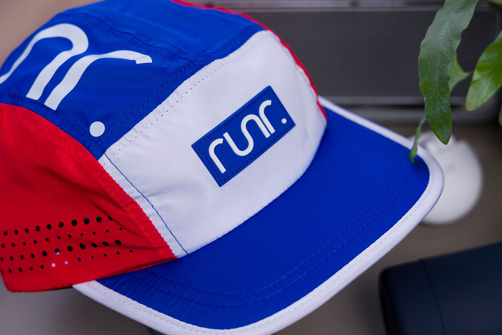 Close-up of running cap with blue, red, and white panels and front run logo