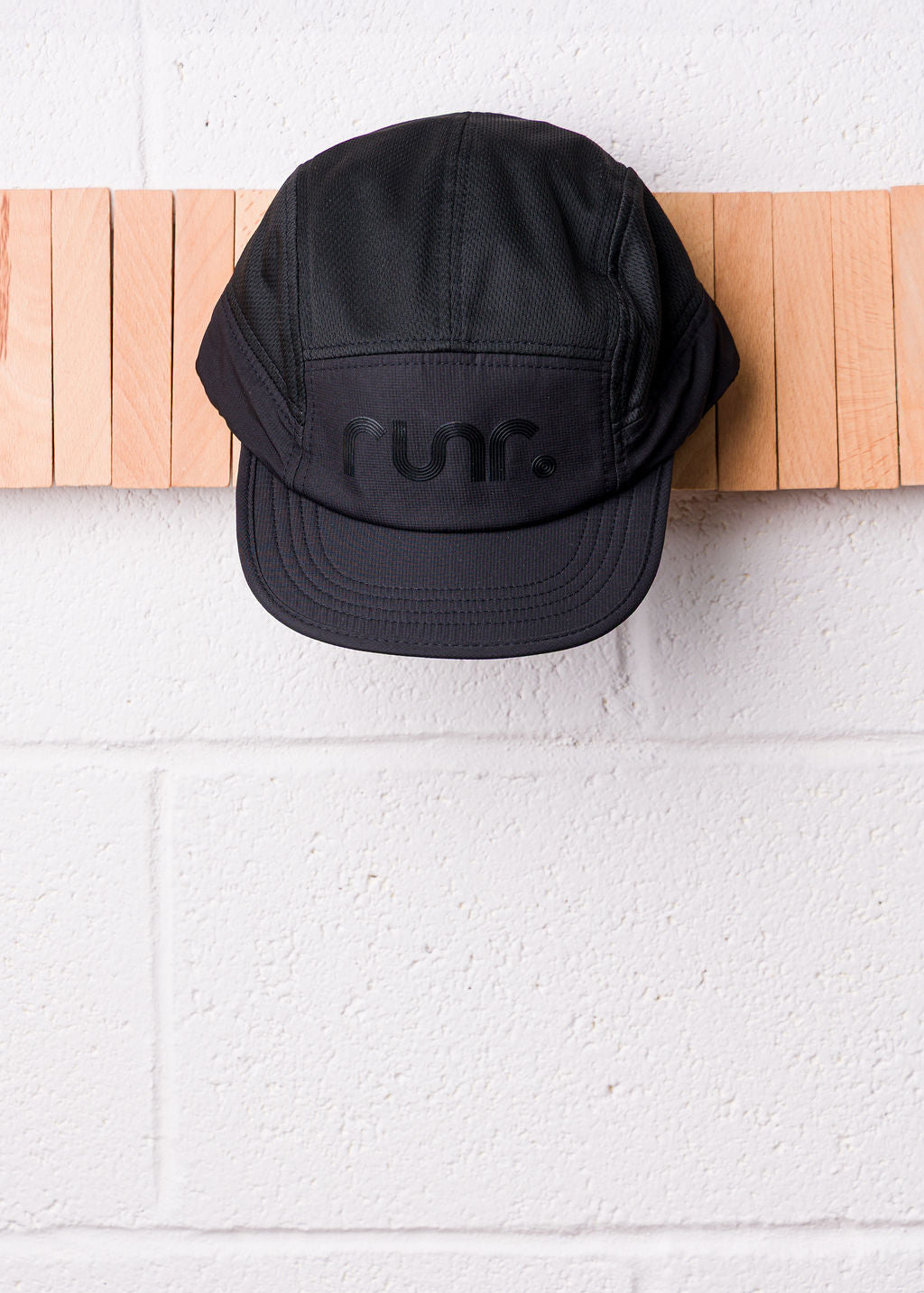 Black technical running cap with r un. logo front panel
