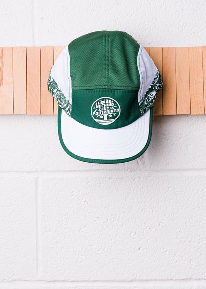 Technical running hat with green crown, white brim, and footprints slogan badge