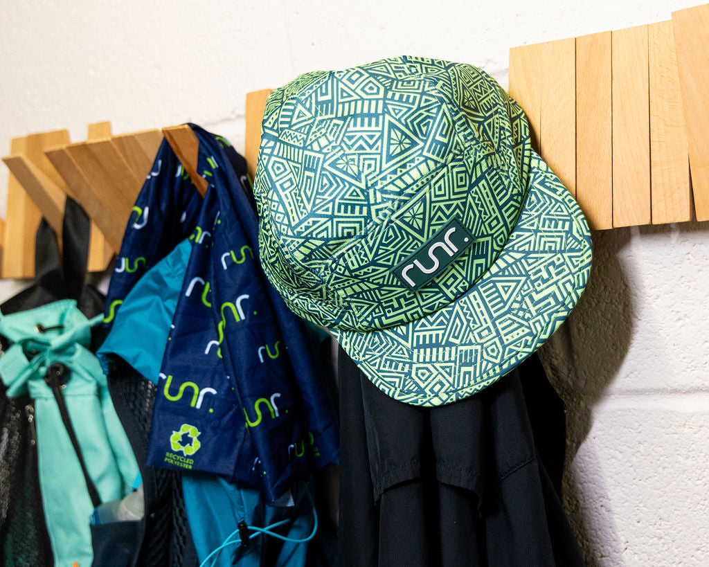 Geo-pattern running hat with black chin strap and green brim