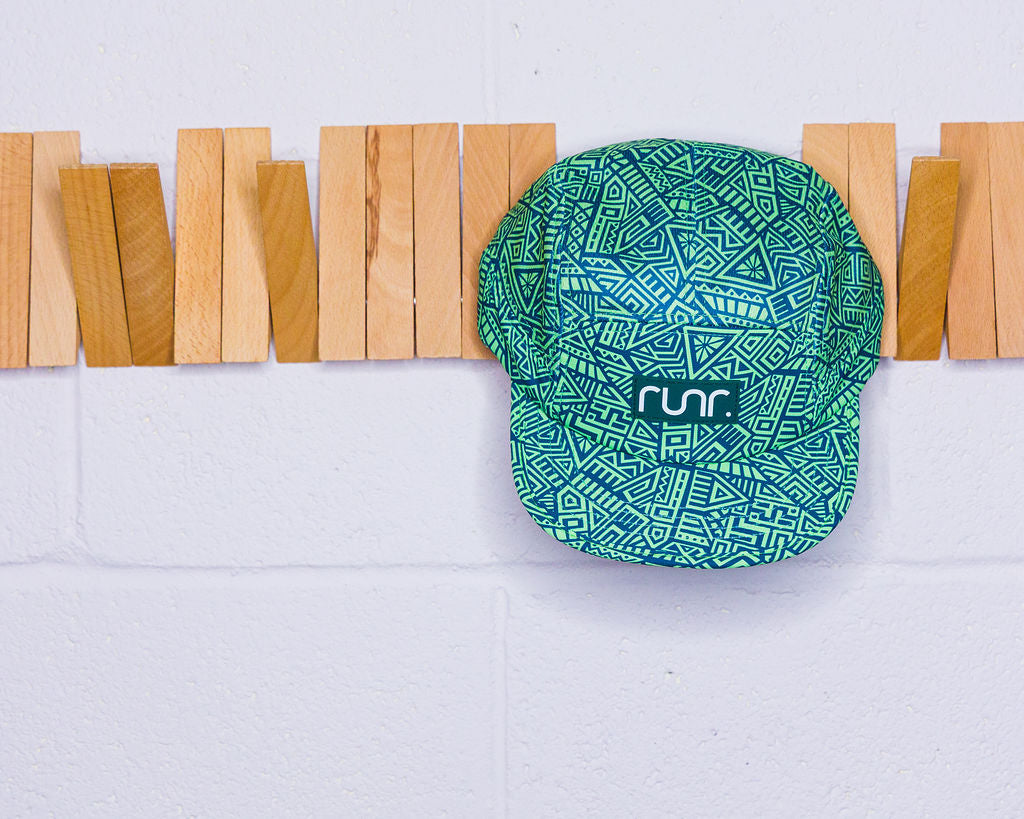 Runr technical running hat in green with blue geometric pattern, curved brim and logo