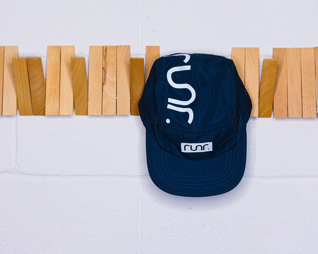 Navy running cap with white runr logo and curved brim
