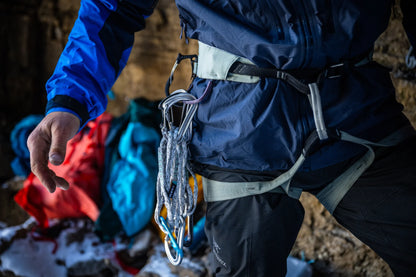 Climbing harness worn on hips with leg loops and hanging gear at the front