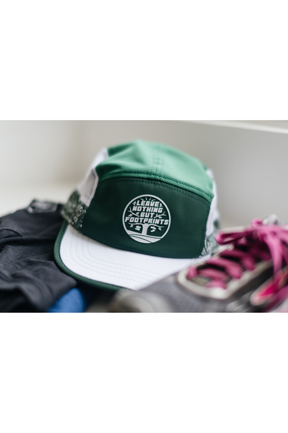 Green and white running cap with leave-nothing foot-print patch on the back panel.