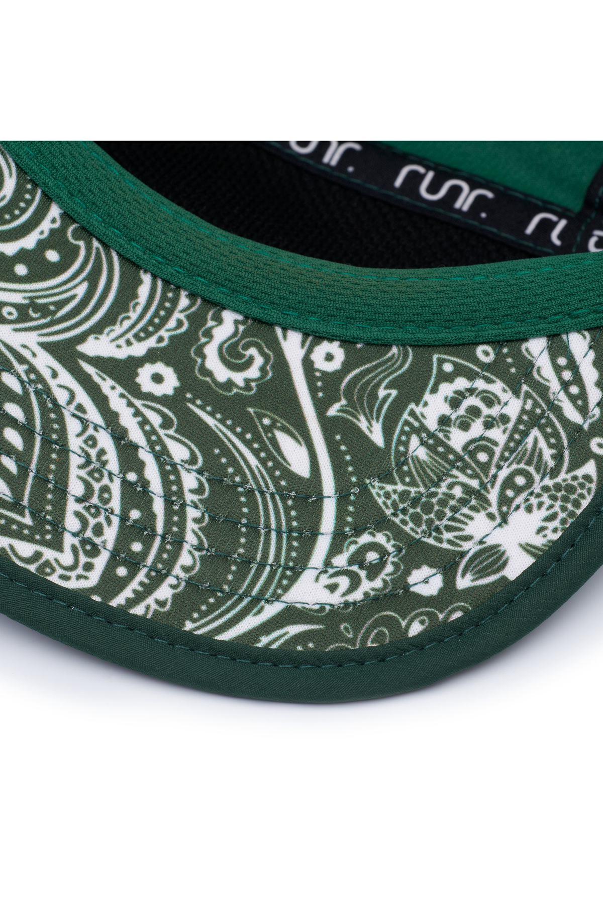 Close-up of green running hat brim with white paisley side panel and dark trim.