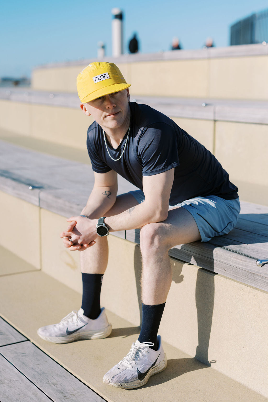 Yellow running hat worn by person, curved brim and front logo