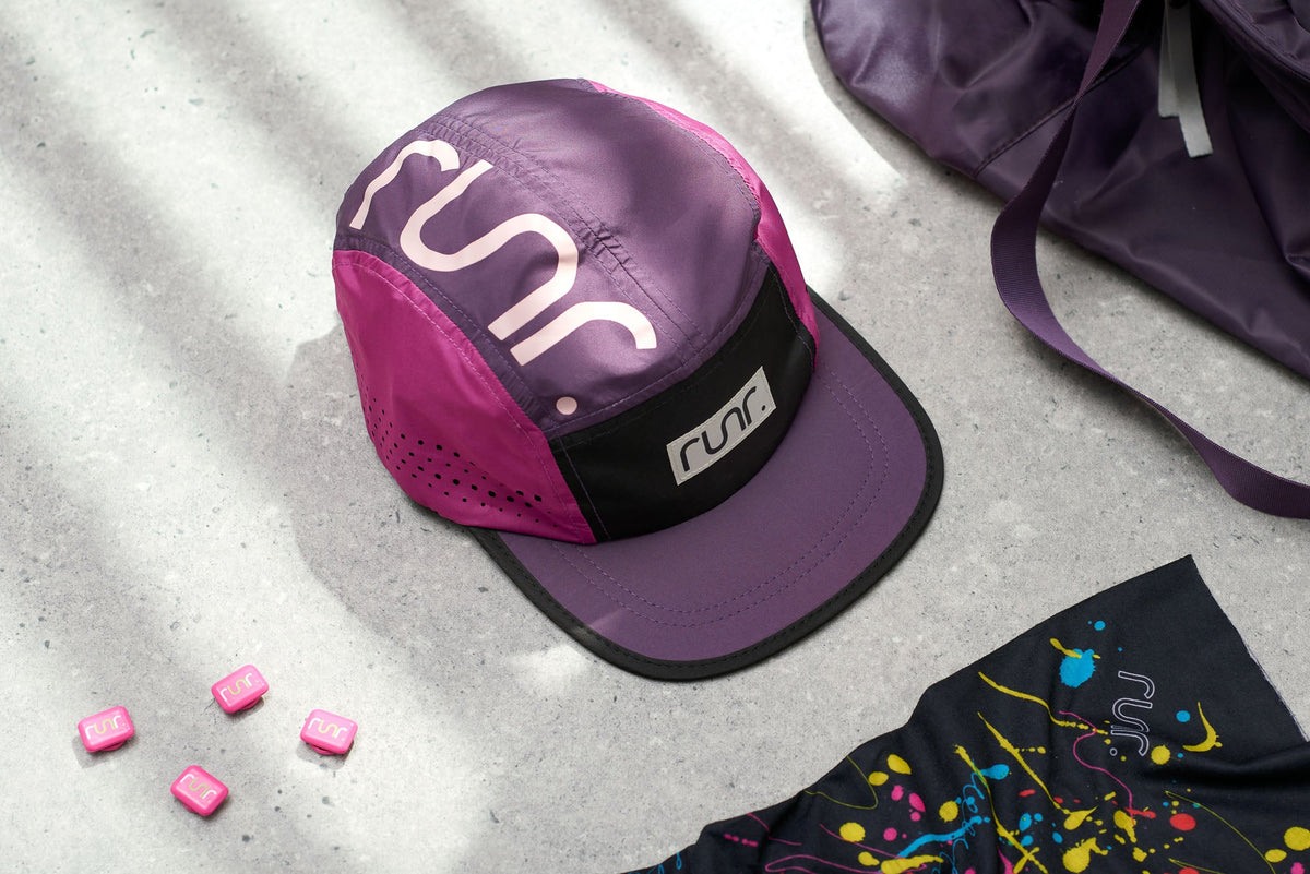 Purple running cap laid with purple and black graphics fabric nearby