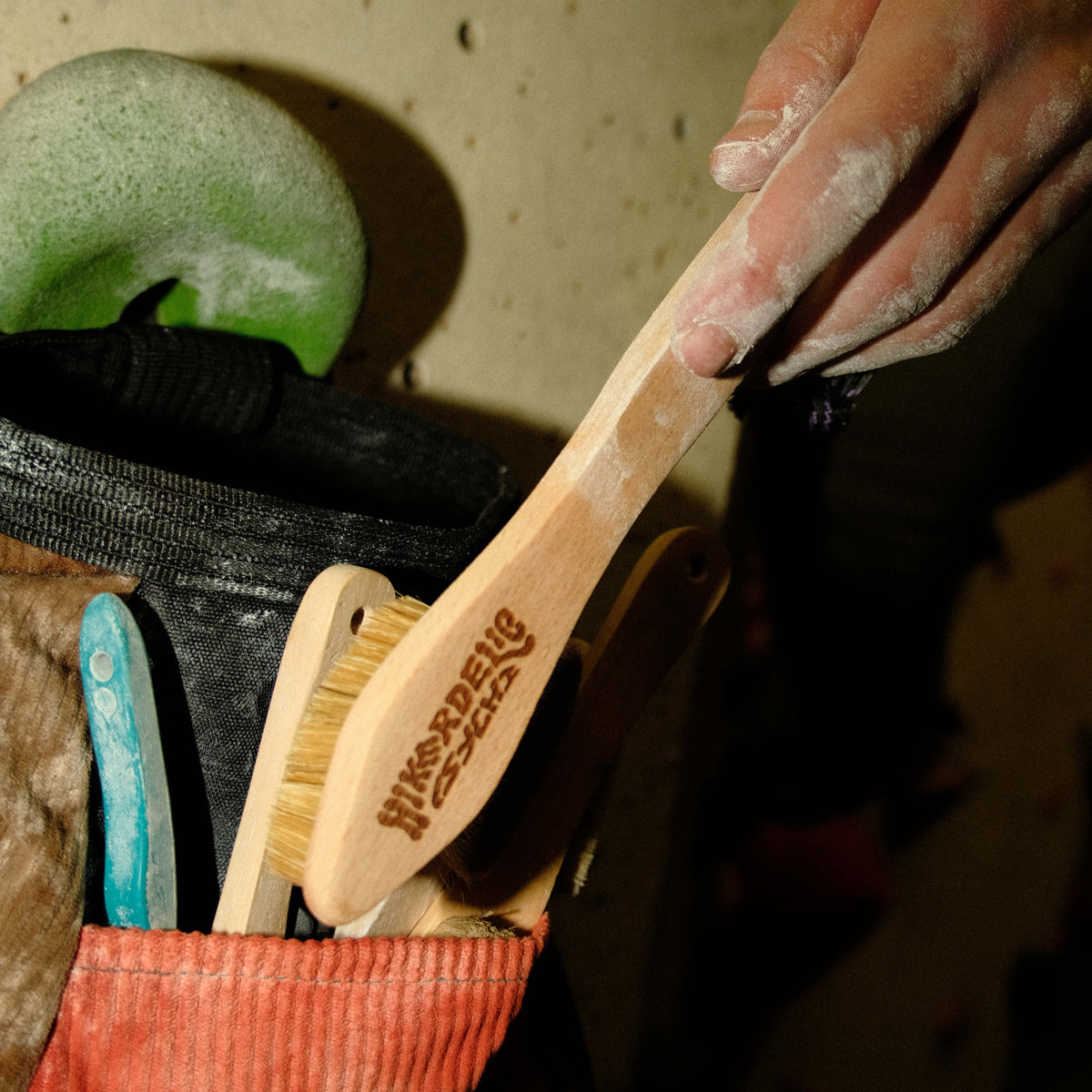 Climbing brush used among gear; boar bristles and light wood handle visible