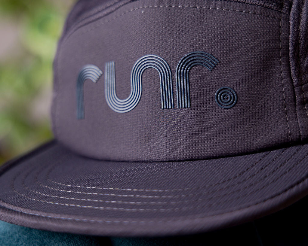 Purple technical running hat close-up with large Runr logo embroidery on front