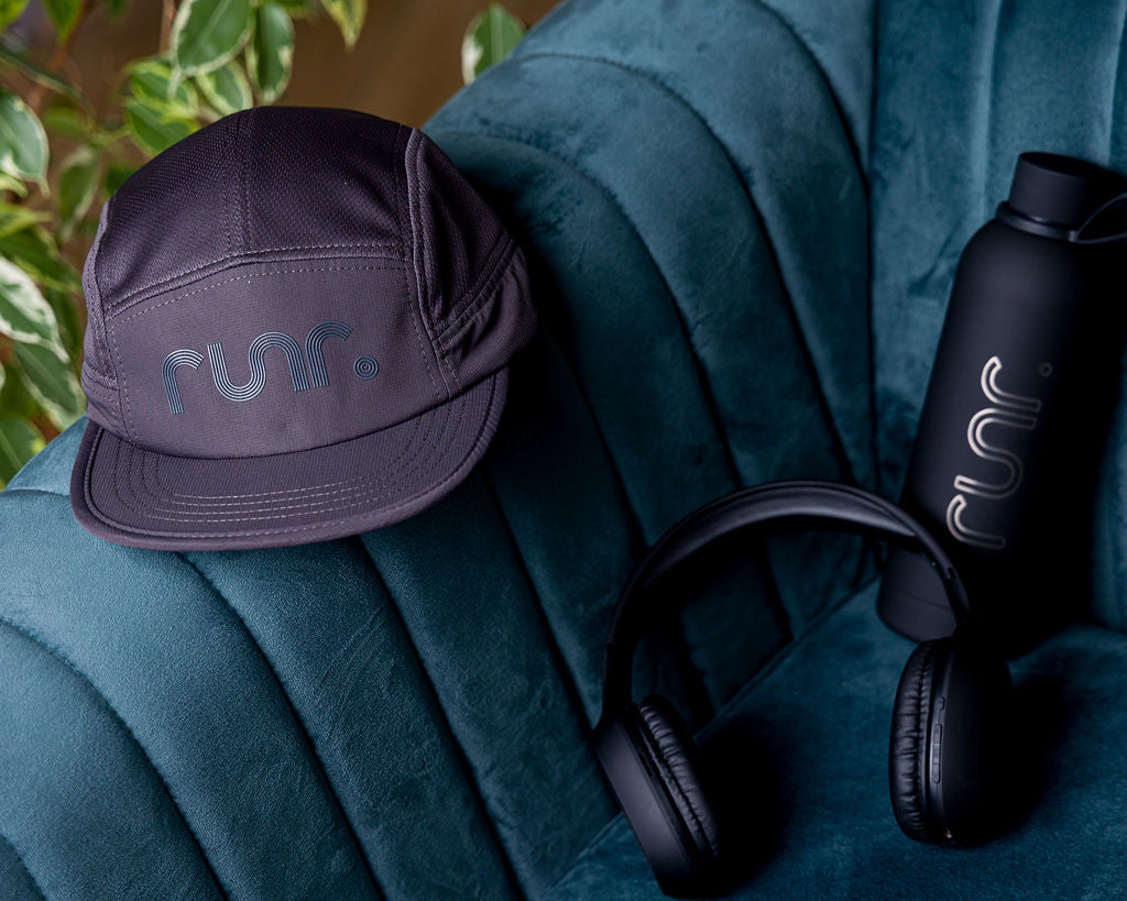 Purple technical running hat close-up with Runr logo and curved brim stitching