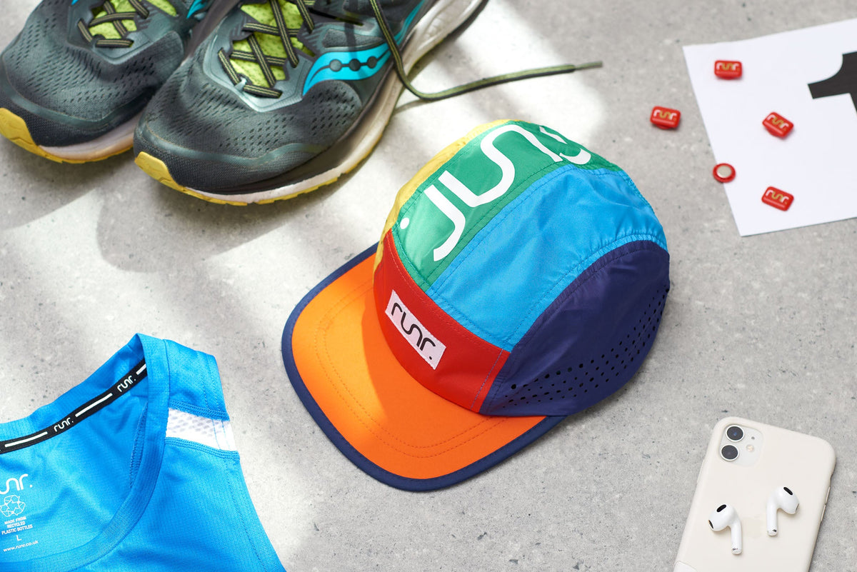 Multicolor technical running cap with RUNR print, laid on gray surface