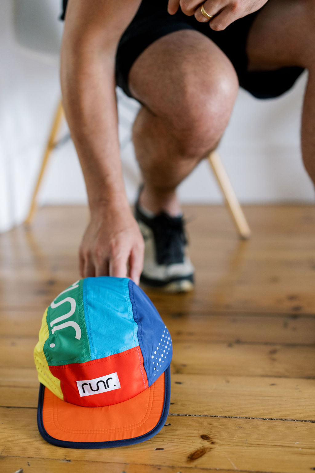 Multicolor running cap on the floor with RUNR patch on side and orange brim