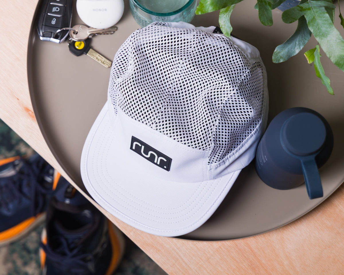 White mesh running hat with black Runr logo patch and curved brim
