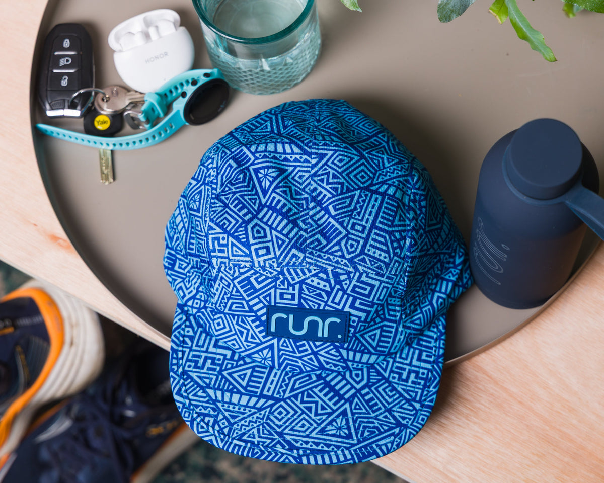 Blue runr technical running hat with geometric pattern, centered logo