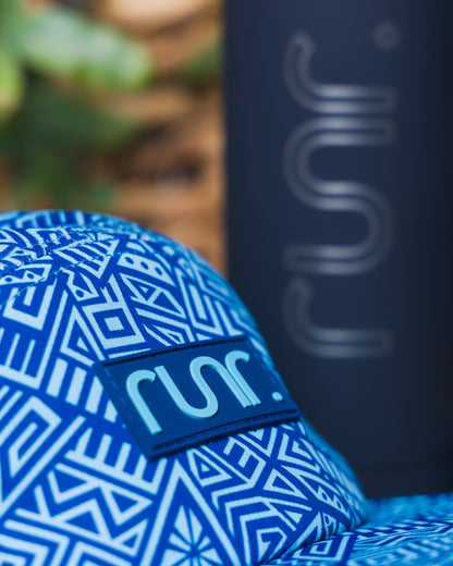 Blue geometric technical running hat close-up with runr logo on front